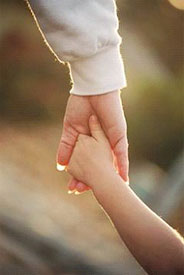 Photo of adult holding child's hand